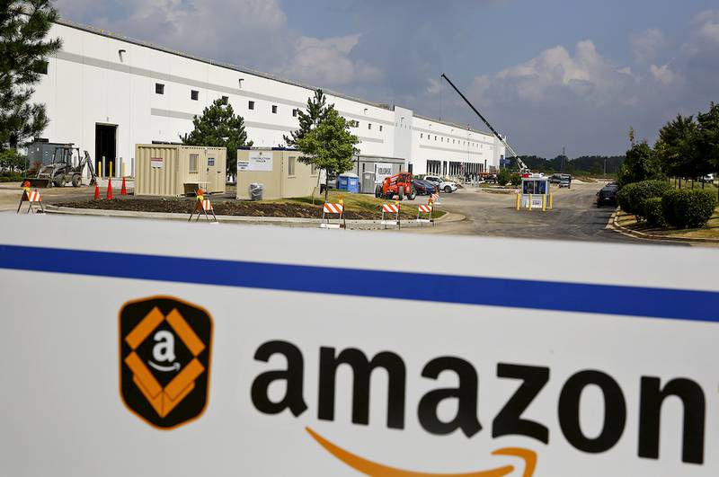 Construction crews work Monday to refurbish an existing warehouse along Laraway Road in preparation for an Amazon fulfillment center in Joliet. The center, which is expected to open later this year, will bring 1,000 jobs to Joliet.