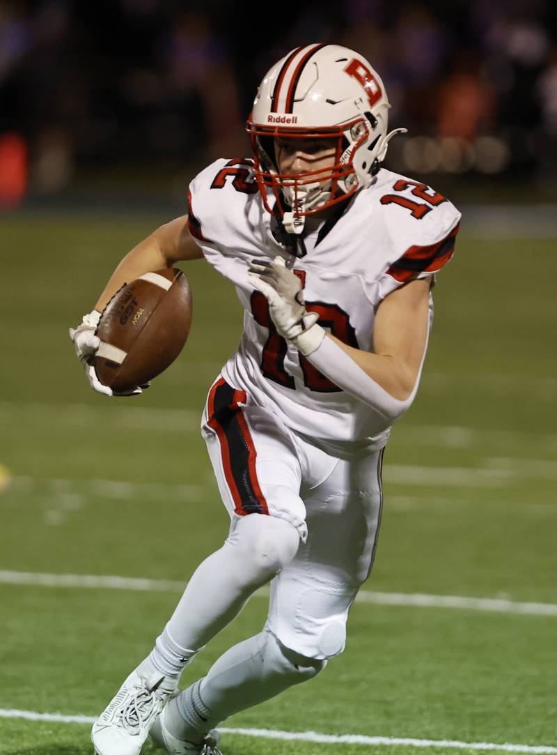 Benet's John Ericson (12) runs the ball during the varsity football game between Benet and Nazareth academies on Friday, Oct. 18, 2024 in La Grange Park.