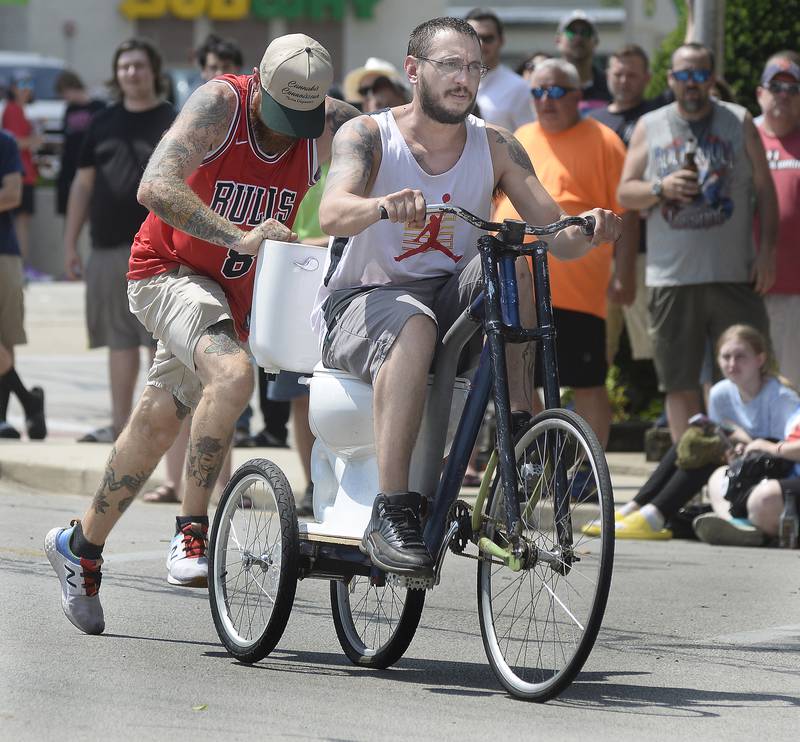 Zach Andrews pushes a toilet cycle for his team mate Steven Cartte during Tuesday’s Toilet Bowl Races as part of Sheridan’s 4th of July celebration.