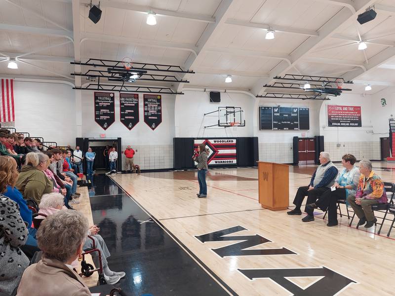 Woodland Hall of Fame inductee Jordan Wicks walks with the microphone to address students, teachers and community members Friday, April 5, 2024, during an assembly at the school's gymnasium.
