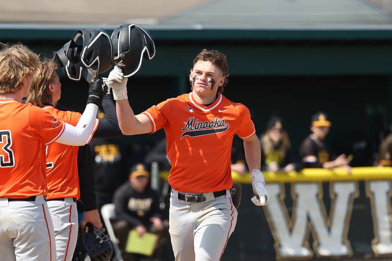 Minooka’s Nate George is greeted by teammates after a solo home run against Joliet West in the WJOL tournament semifinal on Friday, March 29, 2024 in Plainfield.