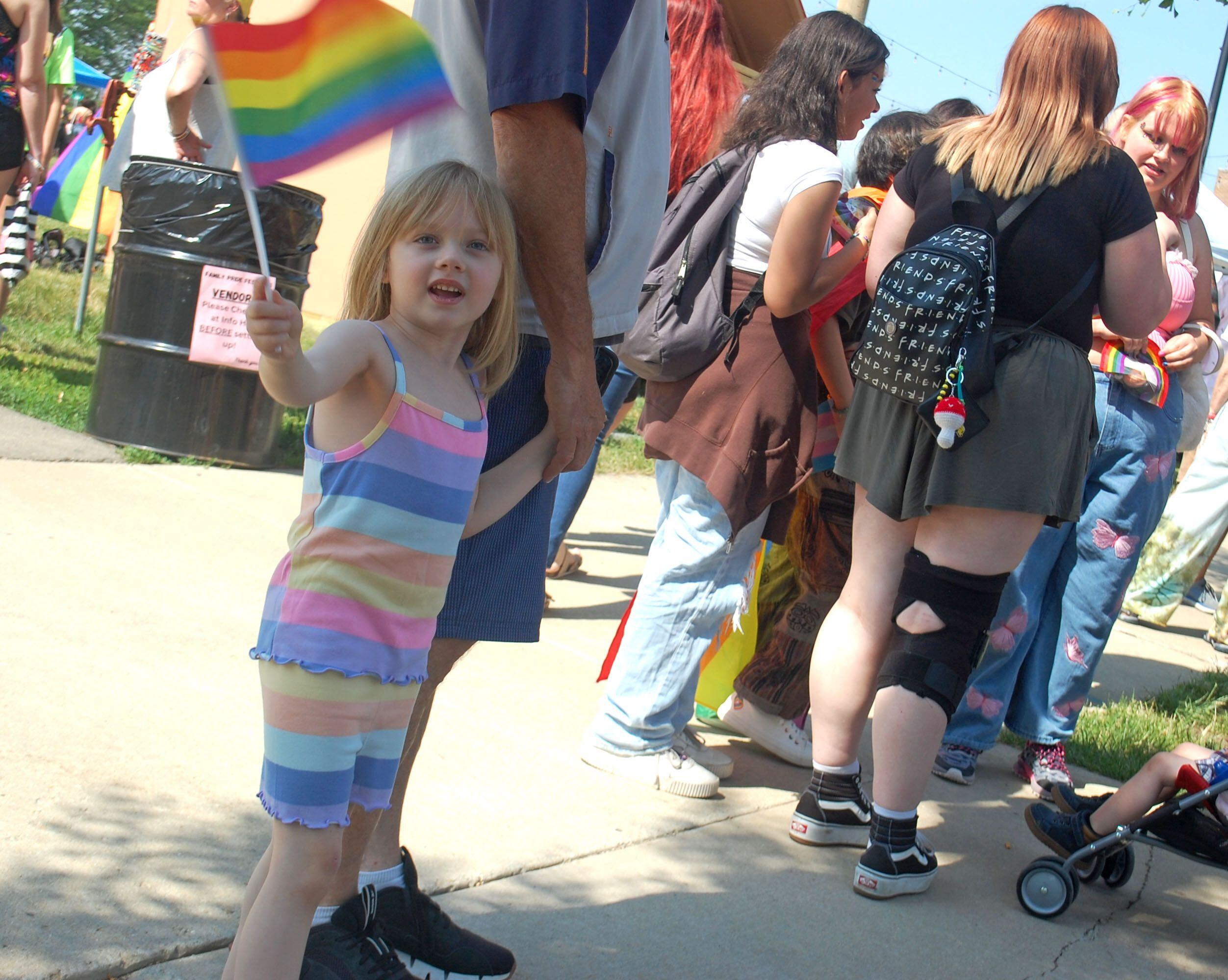 A young visitor waves a Pride flag on the Main Street sidewalk in downtown Ottawa during the second annual Ottawa Family Pride Festival on Saturday, June 10, 2023.