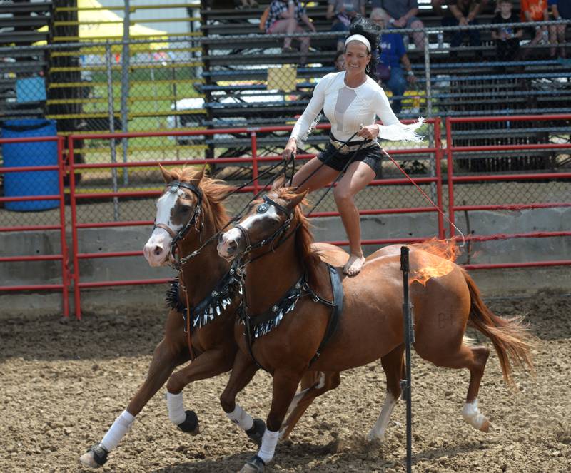 Stunt rider Dusty Crane Dickerson rides two horses around a flaming obstacle in the afternoon session of the Big Hat Rodeo at the Ogle County Fair on Friday, Aug. 4, 2023.