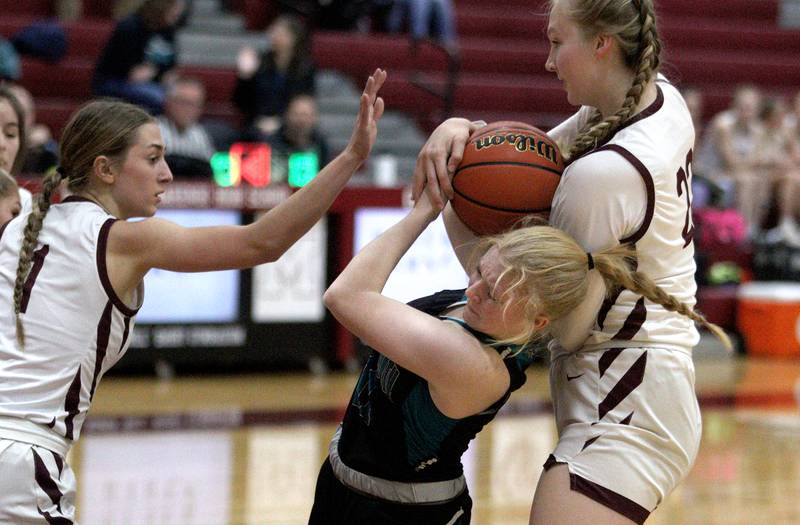 Marengo’s Emily Kirchhoff, left, and Dayna Carr, right, pressure Woodstock North’s Aly Jordan in varsity girls basketball at Marengo Tuesday evening.