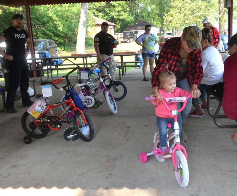 Emily Kester of Prophetstown helps Juniper Kester, 18 months, take a  ride on her new bike that she won at the 17th Dick Brown Fishing Derby for kids at Prophetstown State Park on Saturday.