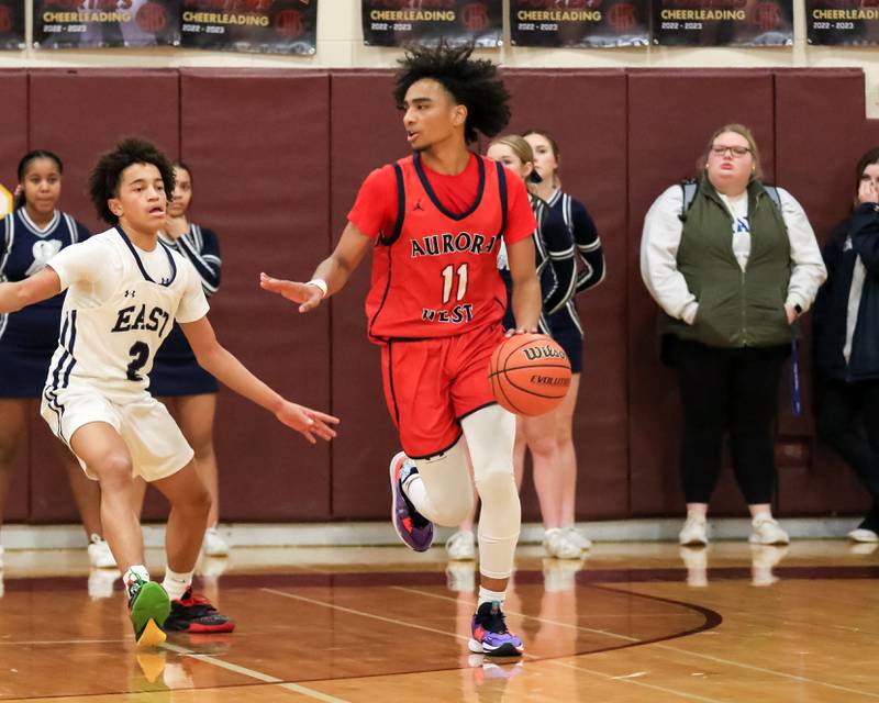 West Aurora's Jordan Brooks (11) handles the ball during Class 4A Lockport Regional final game between West Aurora at Oswego East.  Feb 24, 2023.