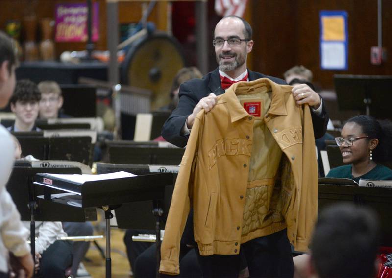 Oregon High School Band Director Andy Eckardt holds the leather Packers jacket he received from members of the band diring the OHS Christmas Concert held Sunday, Dec. 17, 2023 at Oregon High School.