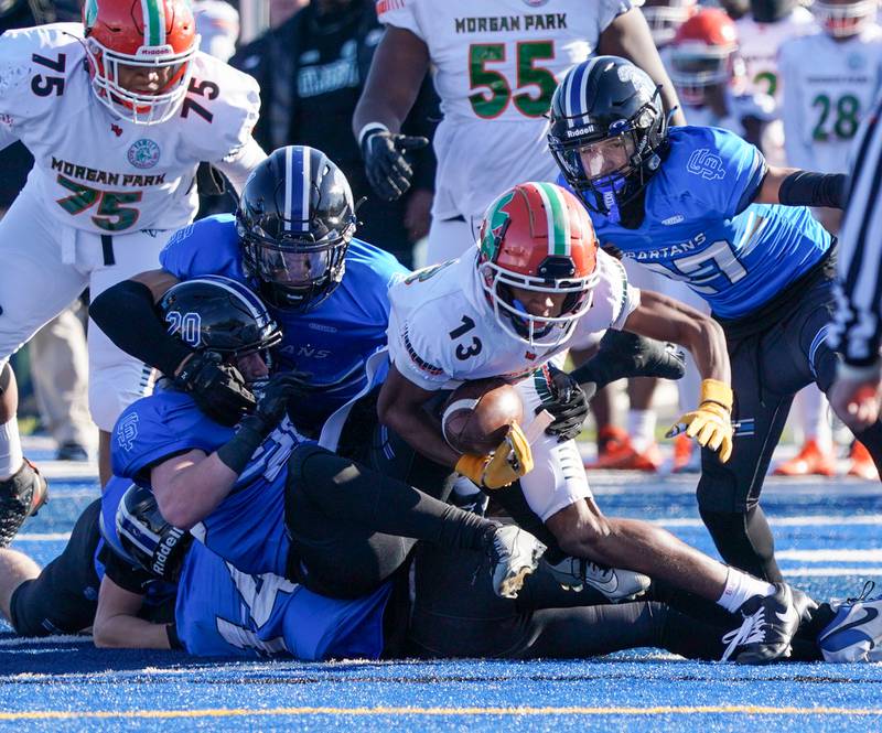 A number of St. Francis defenders swarm on Morgan Park's Chris Durr (13) during a class 5A state quarterfinal football game at St. Francis High School in Wheaton on Saturday, Nov 11, 2023.