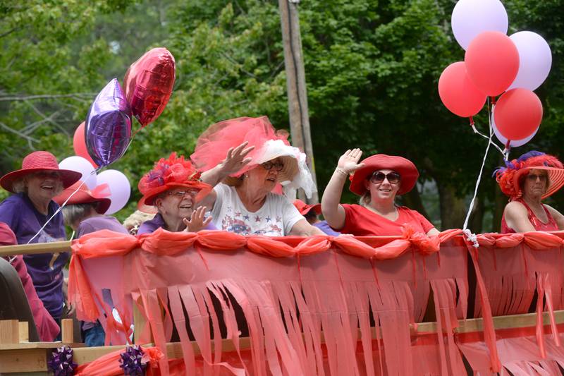 The German Valley Red Hat Ladies wave to the crowd from their float during the German Valley Days parade on Saturday, July 20, 2024.