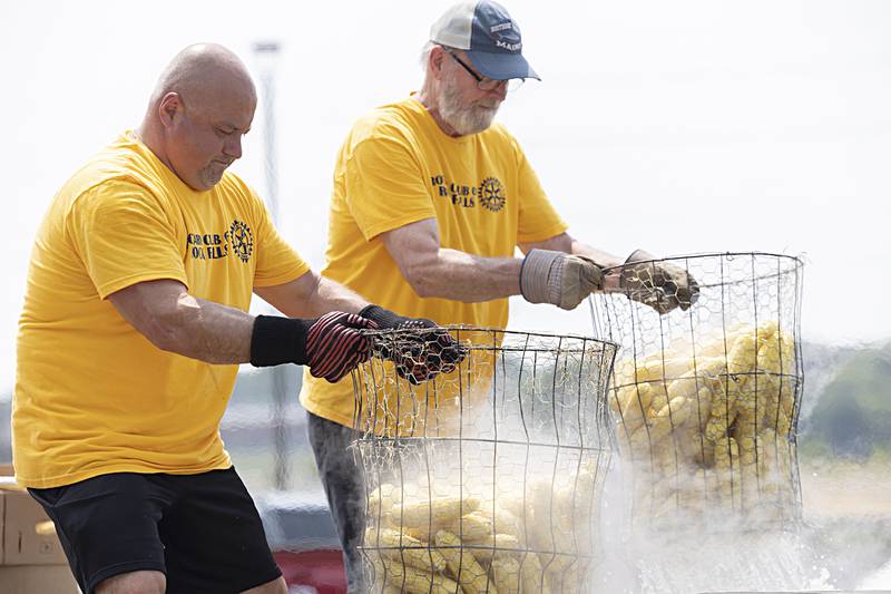 Dave Chavira (left) and Mike Albers haul out hot and tasty ears of corn Monday, July 24, 2023 for the annual Rotary Corn Boil. The summertime staple has been around for 67 years.