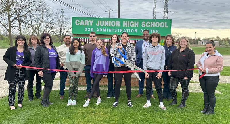 Cary Junior High School assistant principal Stephanie Brashear prepares to cut the ribbon. Pictured (L to R): Ashley Neubauer of Advia Credit Union, Kathy Ewing, Cali Draffkorn of Advia Credit Union, Rafael Casteneda, CJH student Avya Tomar, Doug Katz, CJH student Ella Grimm, Dawn Turner, Brashear, District 26 Superintendent Dr. Brandon White, CJH student Jacob Lima, Lynn Caccavallo, Shannon Morreale and Vesela Nikay