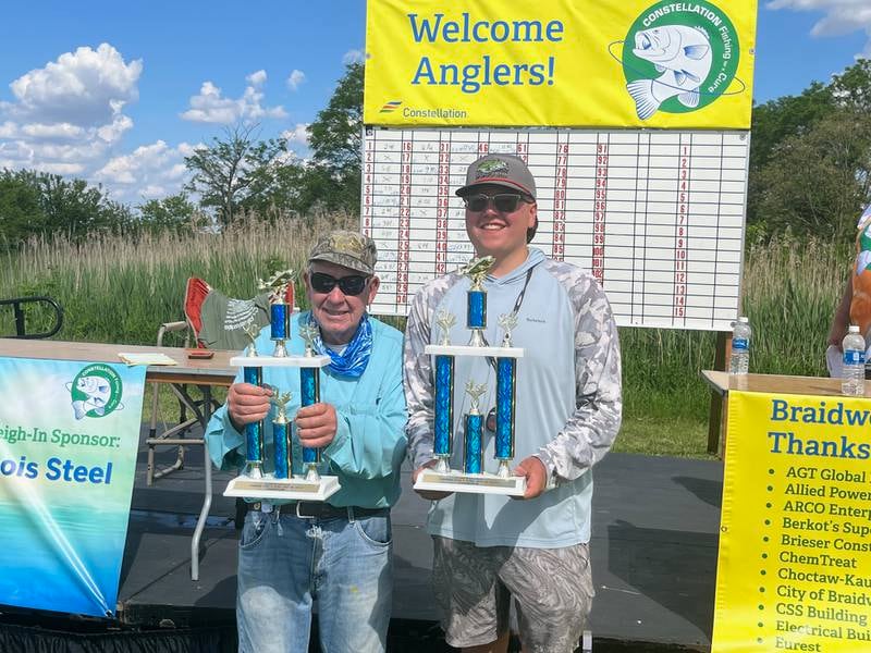 Tournament winners Mike Hzechio (left) and Trey Budach show off their trophies. They won the $4,000 top prize at the annual Fishing for a Cure event, and their three-fish total was 13.49 pounds.