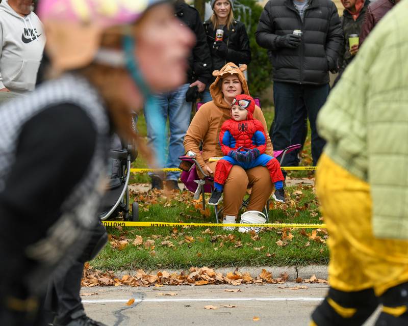 Steph Haines and her son, Flynn MacPartlad, 3, of DeKalb watch as the DeKalb County’s roller derby league passes by during the Sycamore Pumpkin Festival Pumpkin Parade on Sunday, Oct. 29, 2023.