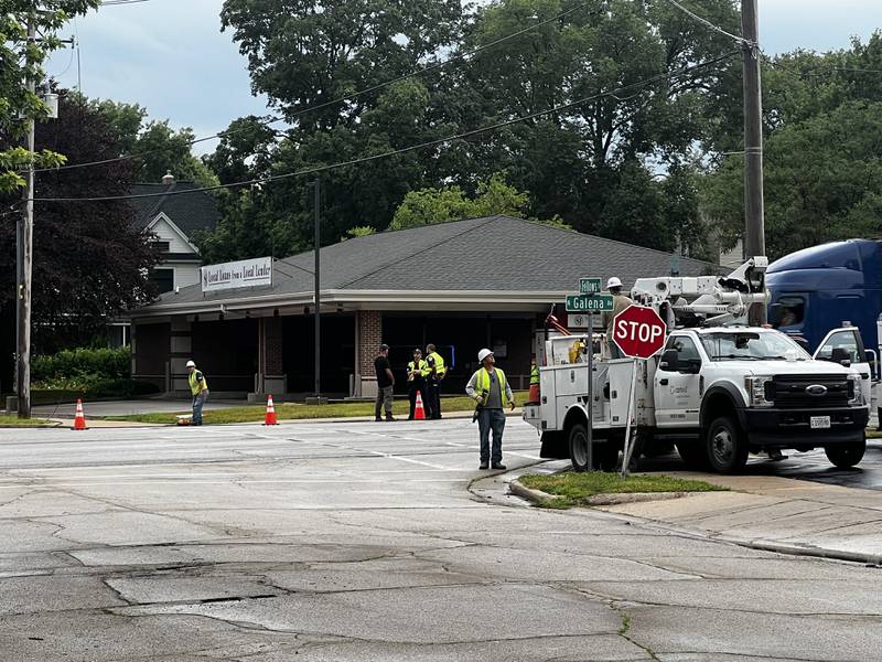 Crews work at the scene of a downed power line Tuesday morning at the corner of North Galena Avenue and East Fellows Street in front of Sterling Federal Bank in Dixon.
