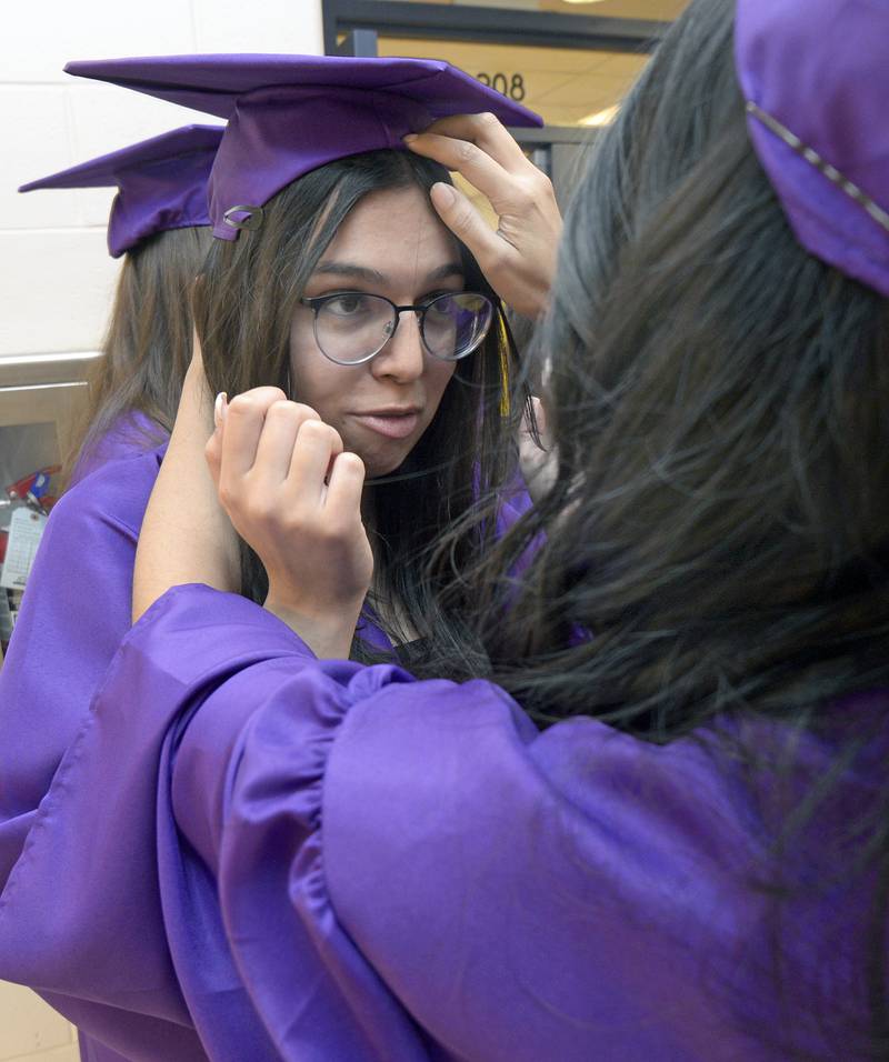 Jasmine Garcia gets a helping hand with her graduation cap as she gets ready for her graduation ceremony Saturday at Mendota High School.