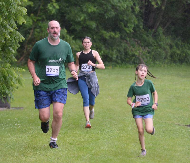 Dane Bell (left), Mara Bell (right) and Mackenzie Turcato (center) run along the lake at the Rochelle Wildlife Conservation Club during the Infinity Event 5K on Saturday, June 8, 2024.