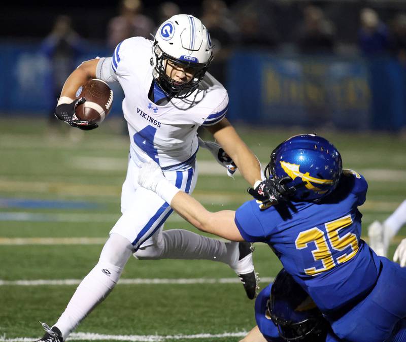 Geneva's Troy Velez (4) looks for running room as Lake Forest's Timotei Dan (35) dives to take him down during the IHSA Class 6A playoff game Friday November 3, 2023 in Lake Forest.