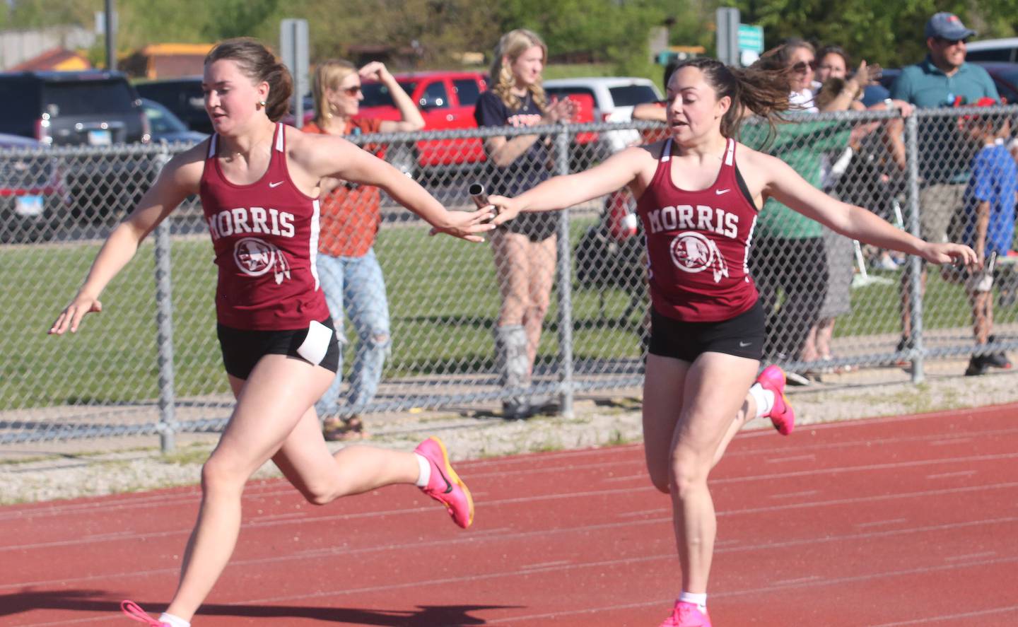 Morris's Hannah Linn reaches for the baton as teammate Makenzie Enger hands her it in the 4x100 relay during the Interstate 8 conference track meet on Friday, May 3, 2024 at the L-P Athletic Complex in La Salle.