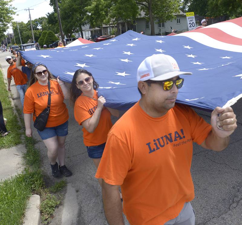 Local Laborers 393 carry a huge American Flag as they march Sunday  in the Marseilles Fun Days Parade.