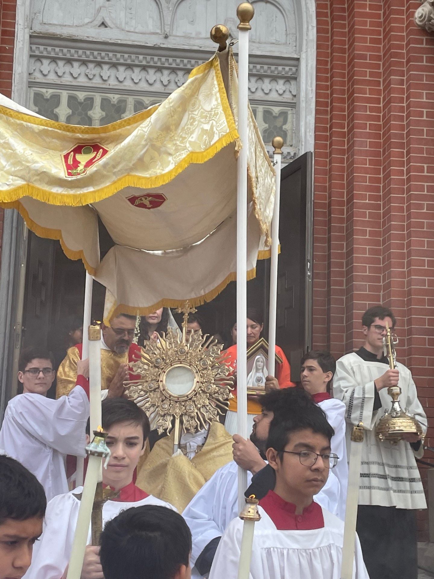 Altar servers from the La Salle Catholic Parishes process ahead of a monstrance carried by the Very. Rev. Tom Otto during the Corpus Christi celebration on Sunday, June 11, 2023.