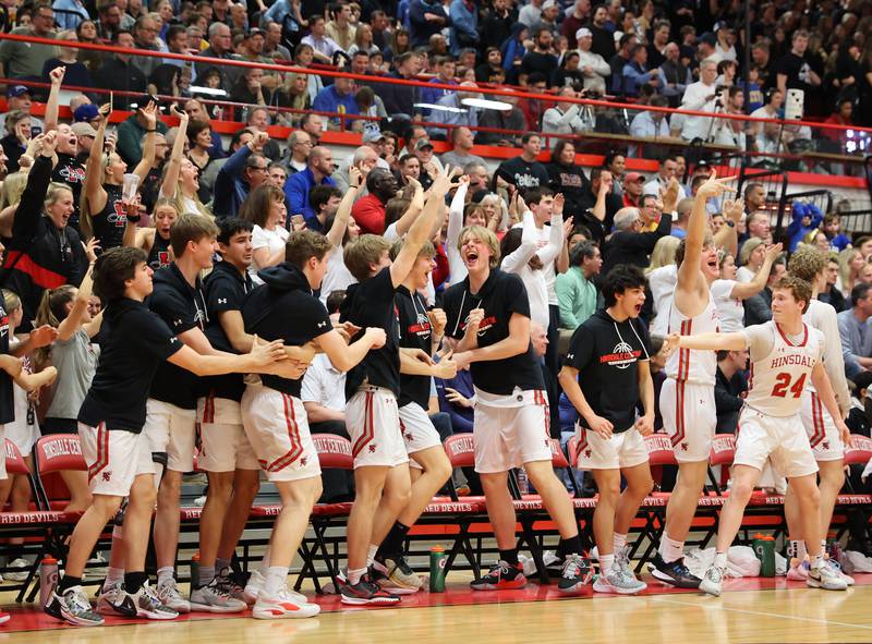 Hinsdale Central's bench reacts to Ben Oosterbaan (12) taking a three-point shot during the boys 4A varsity sectional semi-final game between Hinsdale Central and Lyons Township high schools in Hinsdale on Wednesday, March 1, 2023.