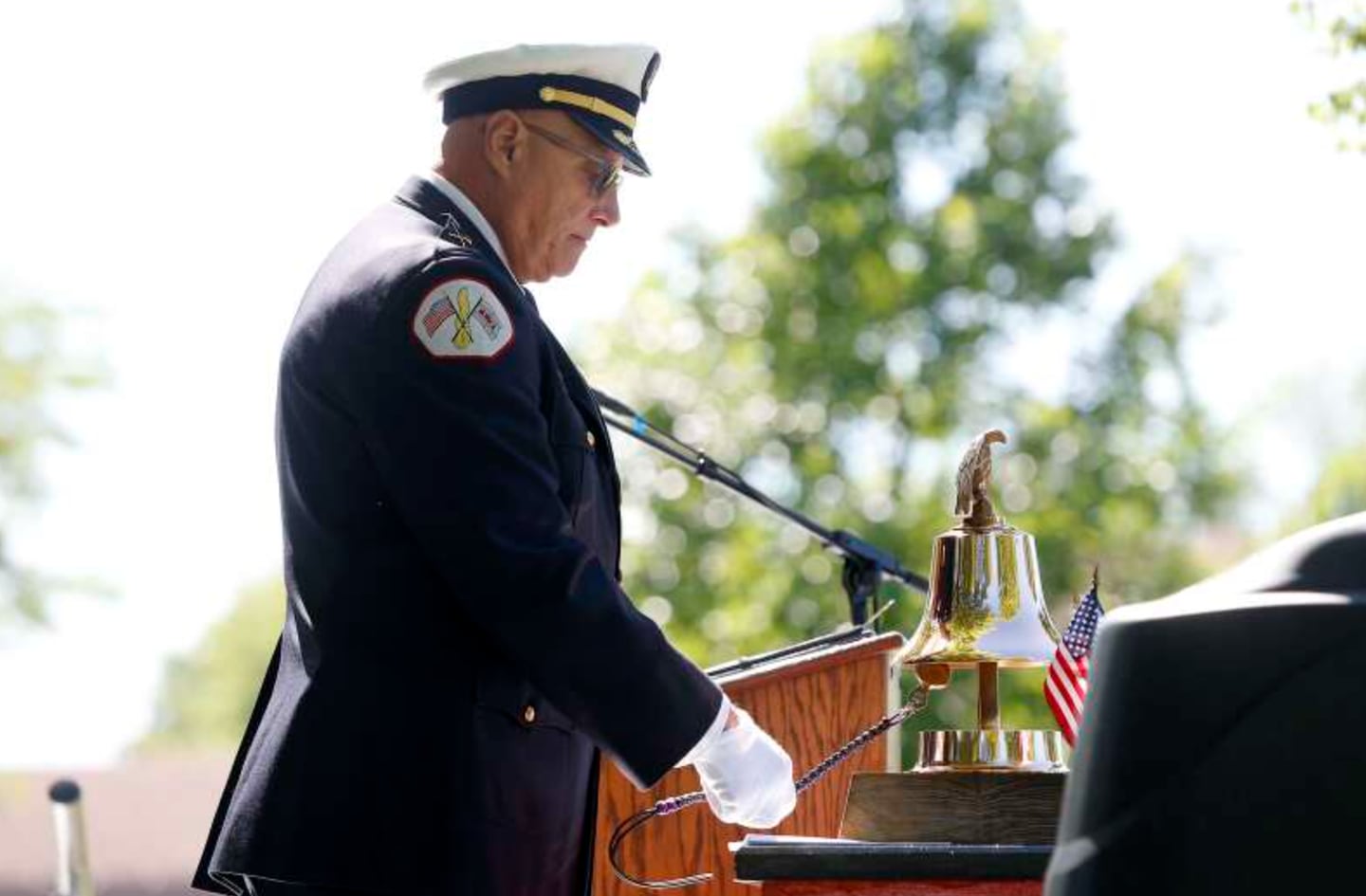 John Jakubec, retired from the Chicago Fire Department, rings the bell at the end of the memorial Saturday for the 45th anniversary of the tragic crash of American Airlines Flight 191 Saturday in Des Plaines.]