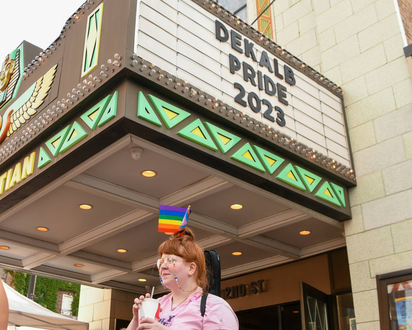 Alex Dawe of DeKalb enjoys a refreshing drink outside the Egyptian Theatre, 135 N. Second St. in downtown DeKalb while waiting for the DeKalb Pride Fest march to begin on Thursday, June 22, 2023.