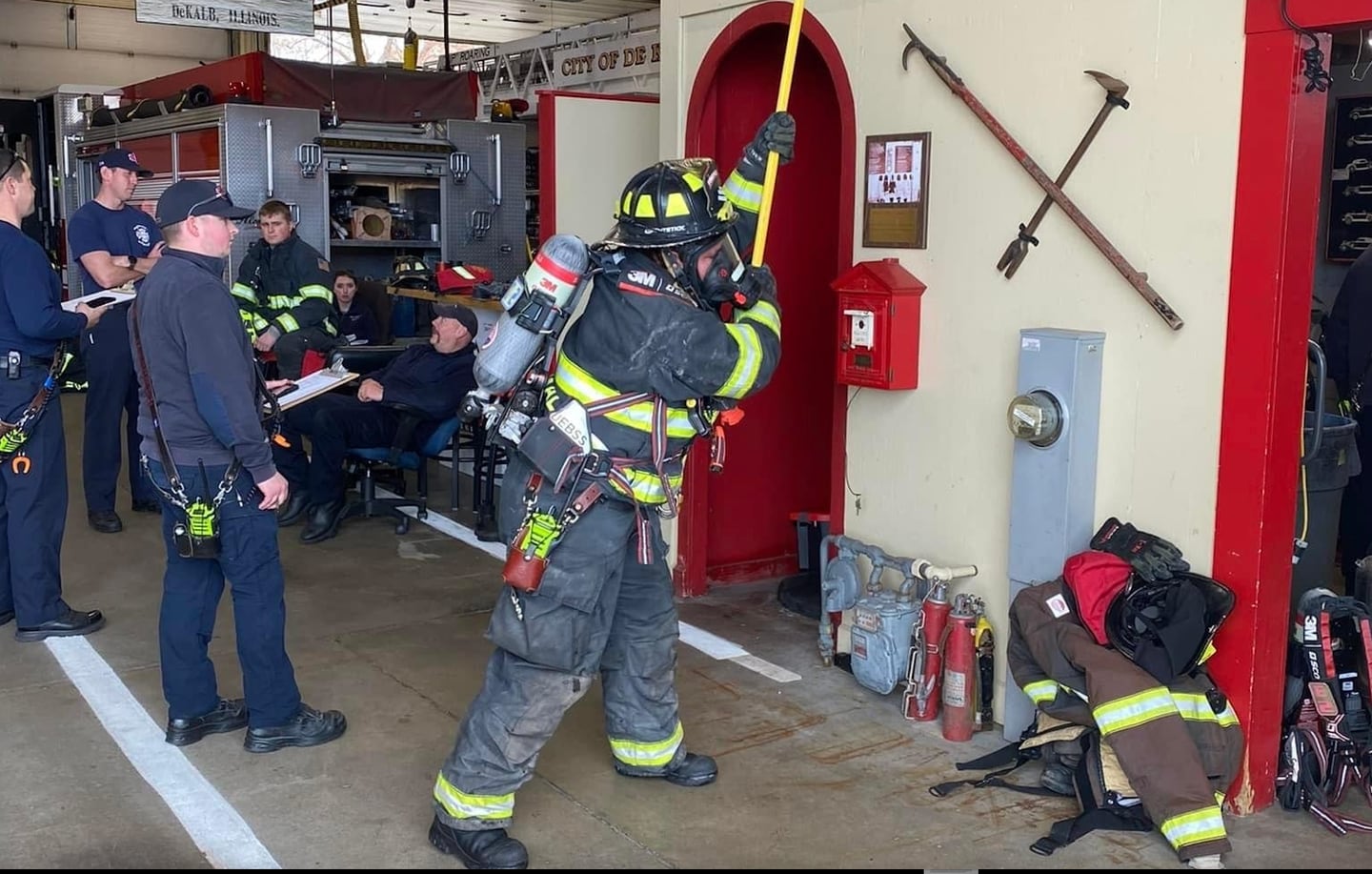 A DeKalb firefighter in full gear pulls a bar to mimic pulling ceiling down as part of an obstacle course-like drill on Wednesday, April 17, 2024, at Station No. 1, 700 Pine St., DeKalb. The consumption drill is meant to help firefighters learn how quickly they'll go through a tank of oxygen during emergency response.