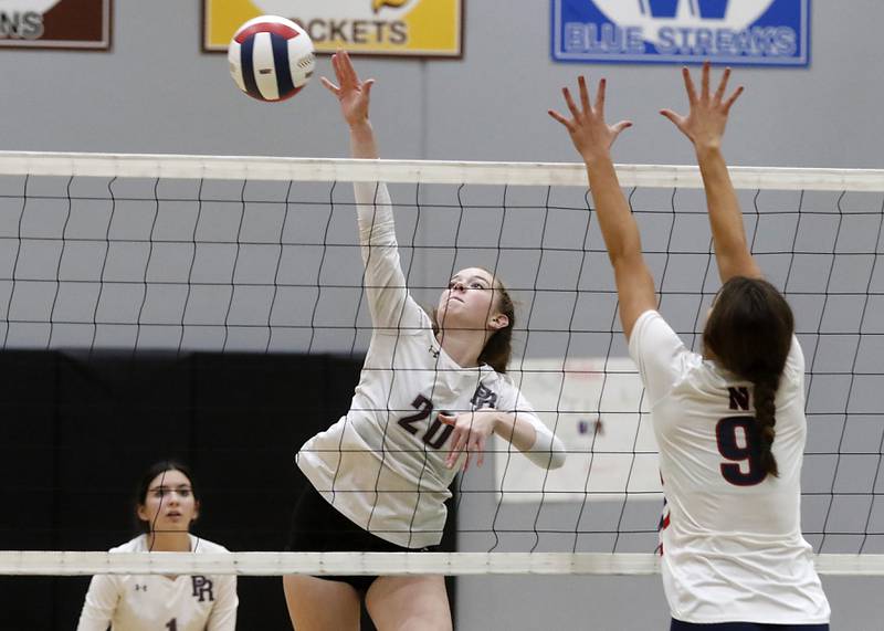 Prairie Ridge's Adeline Grider hits the ball away from the block of Belvidere North's Mya Potter during the Class 3A Woodstock North Sectional finals volleyball match on Wednesday, Nov. 1, 2023, at Woodstock North High School.