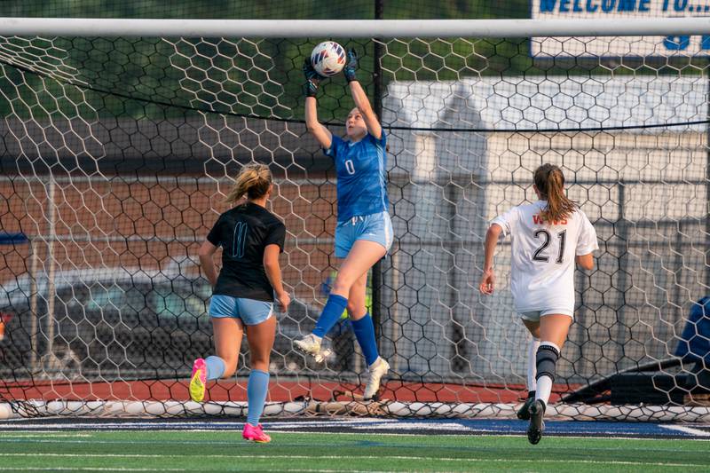 St. Charles North's Kara Claussner (0) goes up high for a save against Wheaton Warrenville South during the Class 3A girls soccer regional final at St. Charles North High School on Friday, May 19, 2023.