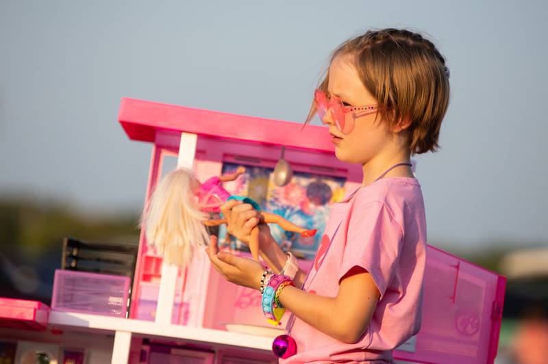 Emma Sault, 8, plays with a Barbie in the back of a pickup truck during the "Barbie" movie premiere at the McHenry Outdoor Theater on Friday,  July 21, 2023.