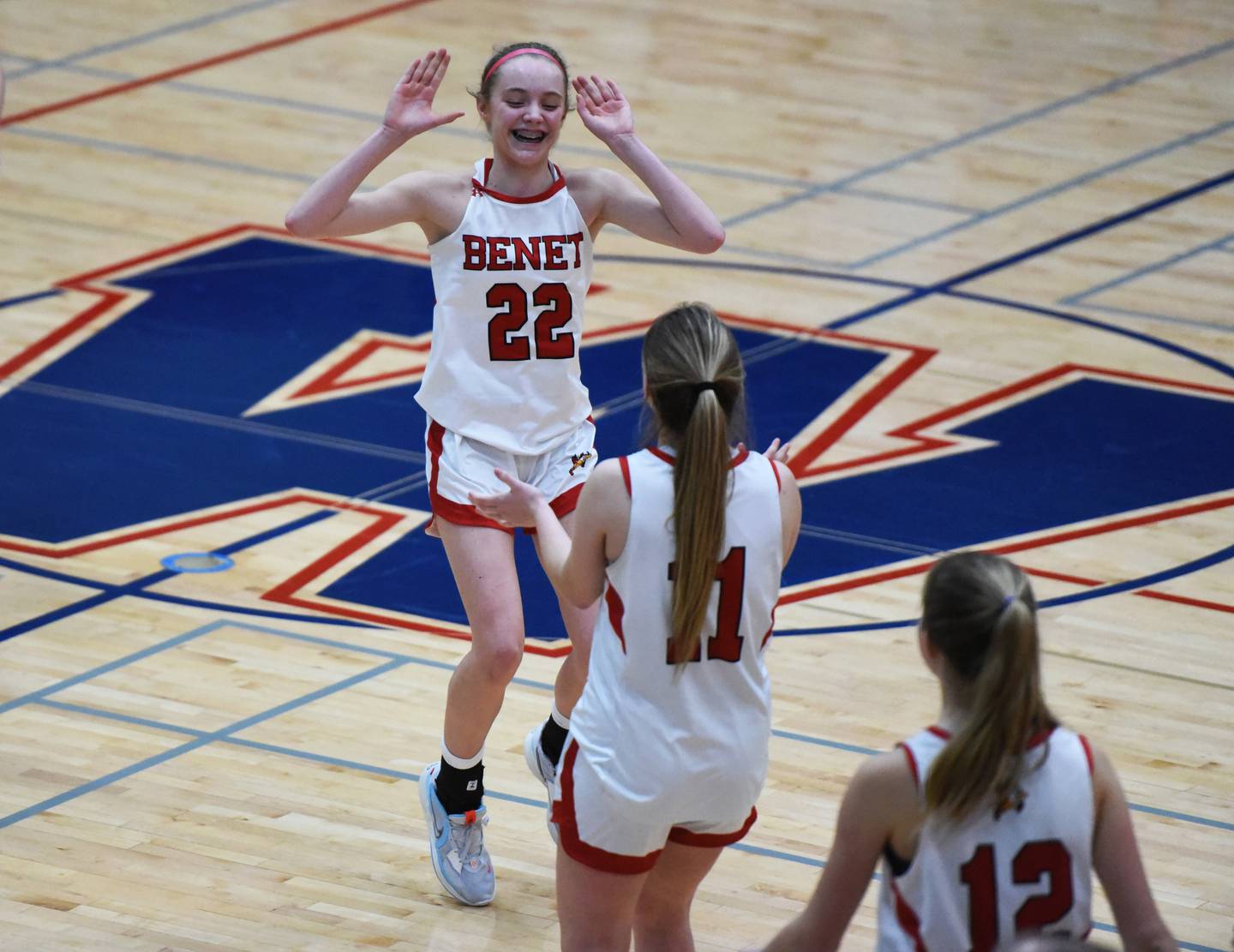 Benet's Bridget Rifenburg (22) congratulates teammates after defeating Neuqua Valley in Tuesday’s IHSA Class 4A regional semifinal girls basketball game in Aurora.