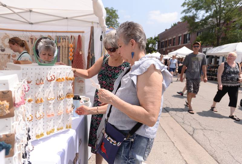 (left) Denise Labedz of Brookfield and Sharon Tyrrell of Palos Hills look at some of the Finch Fen earings at the LaGrange Craft Fair held Saturday, July 13, 2024.