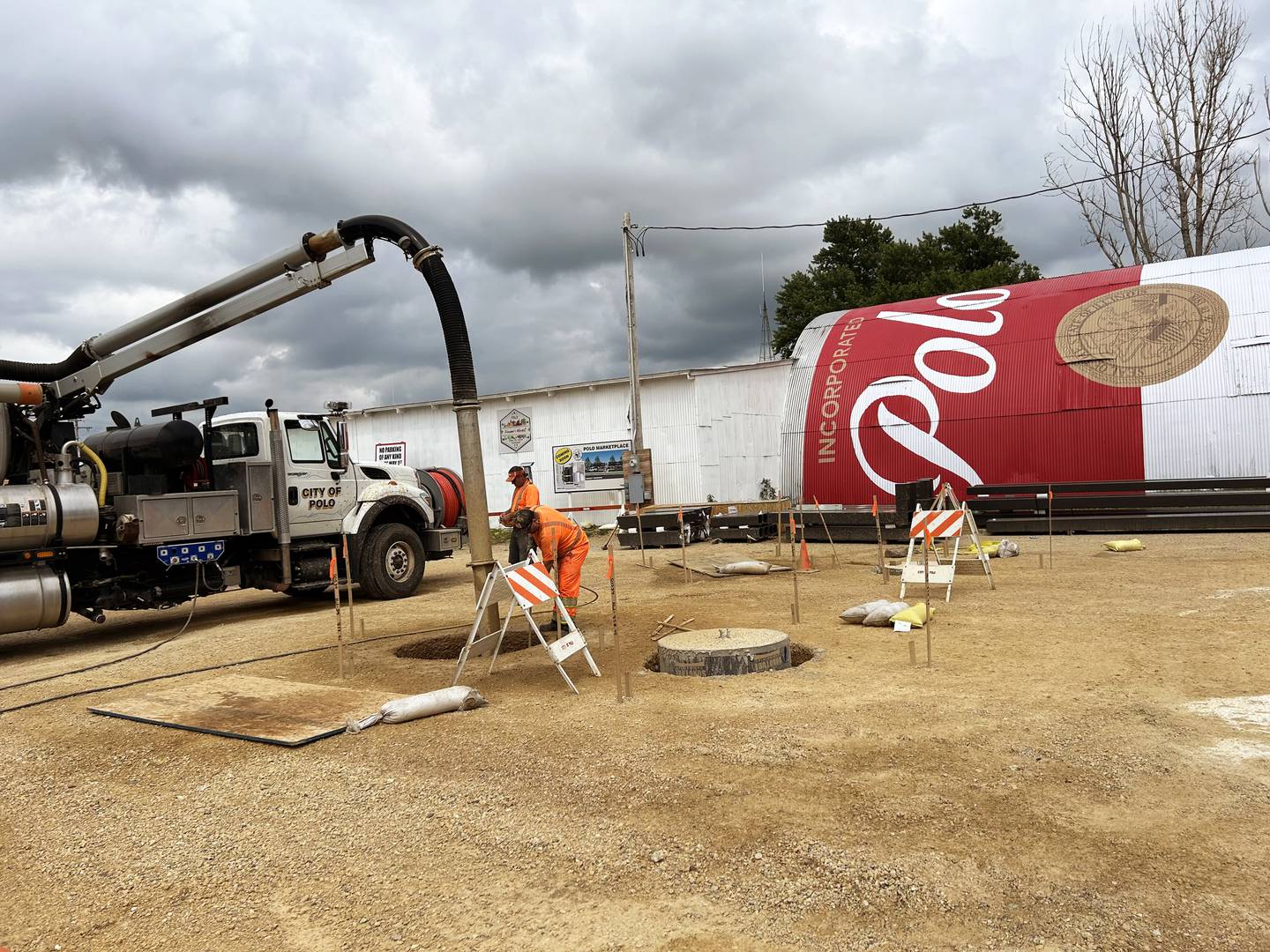 Polo city employees work to prepare the city-owned lot at 212 S. Division Ave. for the erection of two pavilions.