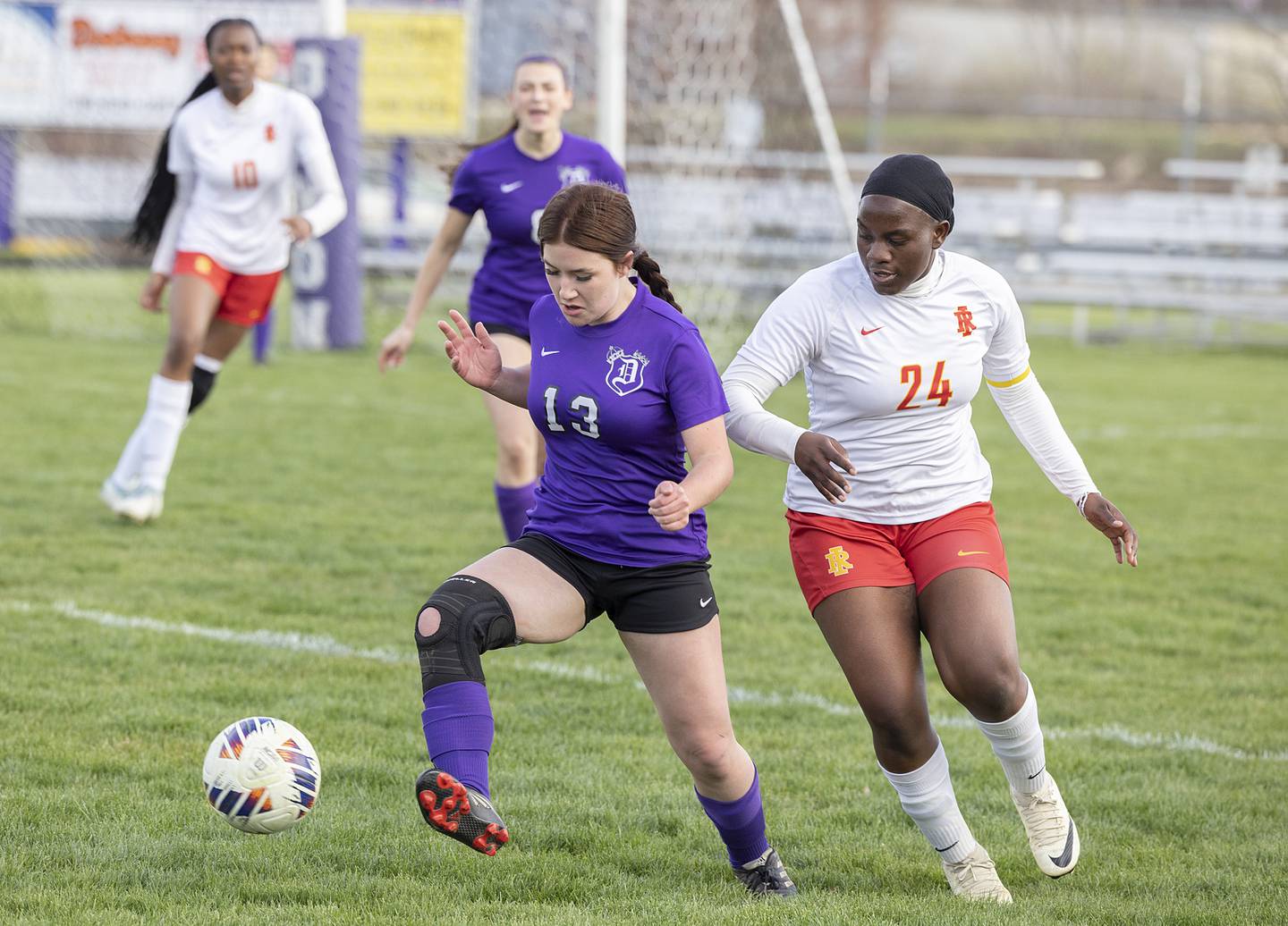 Dixon’s Kailey Helfrich handles the ball in front of Rock Island’s Brigitte Nininahazwe Friday, April 12, 2024 in Dixon.