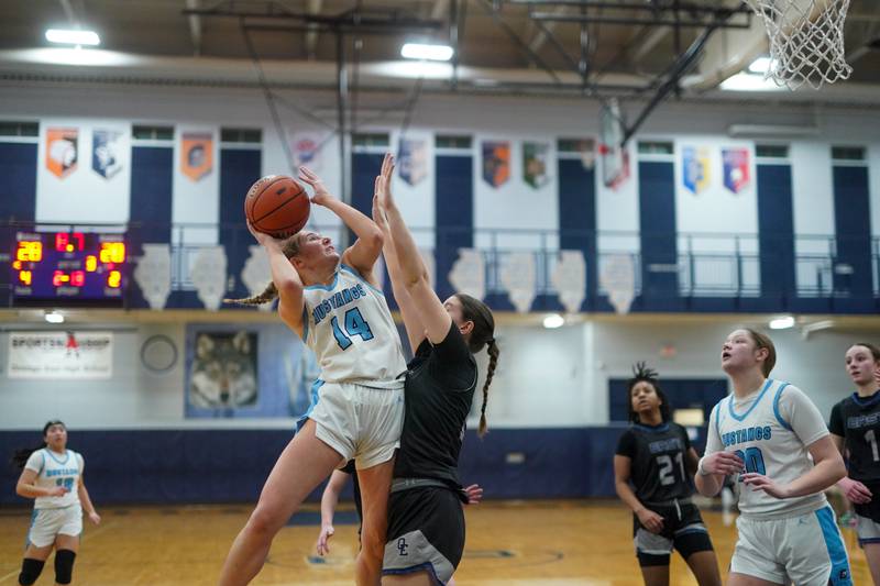 Downers Grove South's Allison Jarvis (14) shoots the ball in the post against Oswego East's Ava Valek (24) during a 4A Oswego East Regional semifinal girls basketball game at Oswego East High School on Monday, Feb 12, 2024.