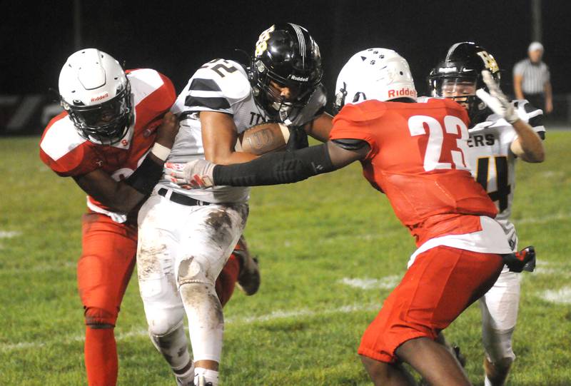 Streator's Tyrese Hendrix and Jordan Lukes (23) team up to take down Herscher's Alex Draper (22) as his teammate, Connor Massie-Devore, tries to assist at Doug Dieken Stadium on Friday, Sept. 22, 2023.