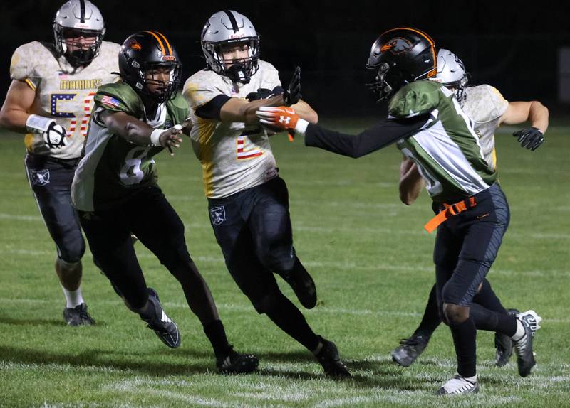 Kaneland's Dylan Sanagustin splits two DeKalb defenders for a nice gain during their game Friday, Sept. 13, 2024, at Kaneland High School in Maple Park.