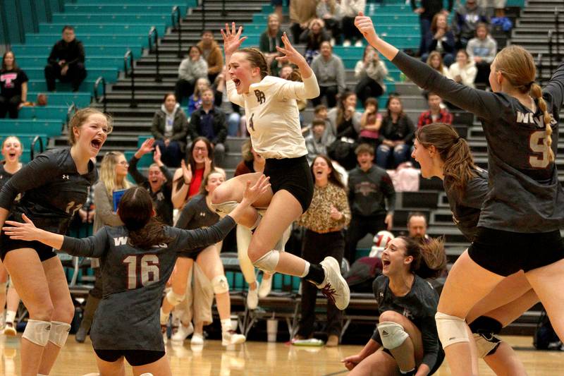 Prairie Ridge’s Wolves collect at center court after the final point falls in a three-set win over Woodstock in IHSA Class 3A sectional semifinal volleyball action at Woodstock North Monday.