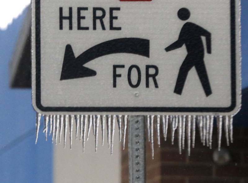 Ice hangs from a pedestrian crossing sign in the parking lot of the Walmart store in Woodstock on WedneA hangs from a pedestrian crossing sign in the parking lot of the Walmart Supercenter in Woodstock on Wednesday, Feb 22, 2023, as winter storm that produced rain, sleet, freezing rain, and ice moved through McHenry County. sday, Feb 22, 2023, as winter storm that produced rain, sleet, freezing rain, and ice moved through McHenry County.