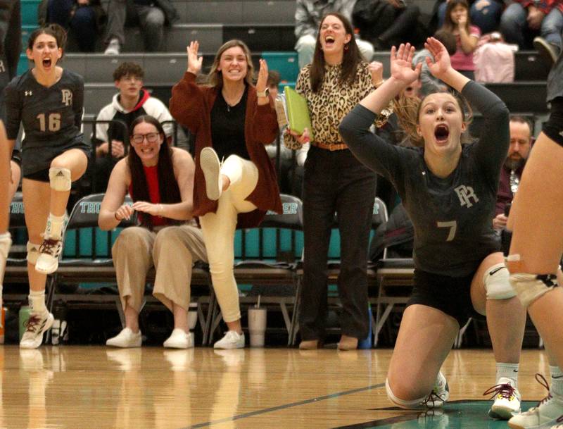 Prairie Ridge’s Addison Gertz (7) and the Wolves bench celebrate a point against Woodstock in IHSA Class 3A sectional semifinal volleyball action at Woodstock North Monday.