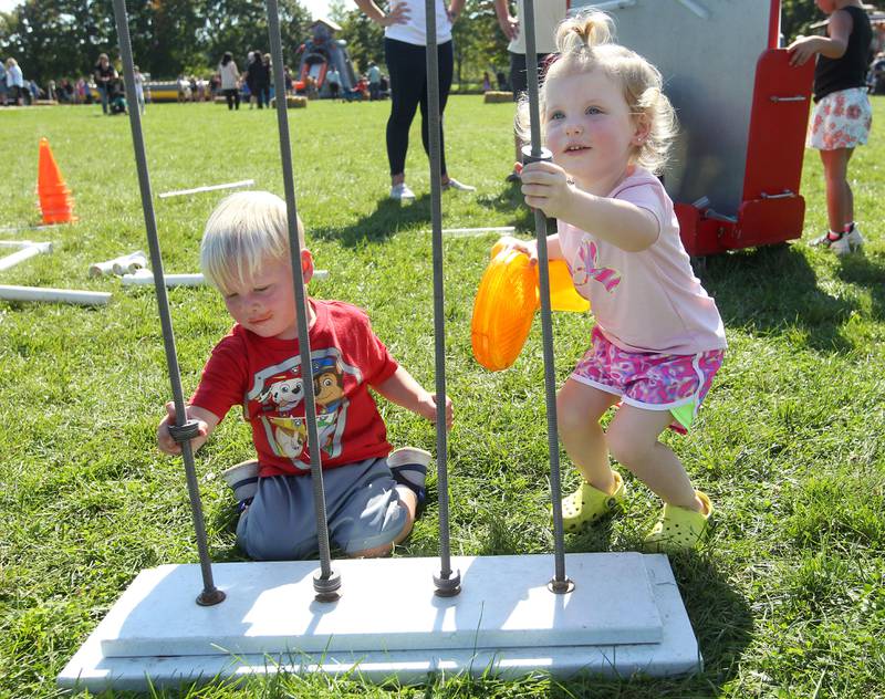 Braxton Lessner, 18 months, of Round Lake and his cousin, Harlow Ziebell, 2, of Volo play with a Busy Brains Children's Museum interactive exhibit during the Fall Festival at Grant Township Center on Oct. 1 in Ingleside. The event was sponsored by the Village of Fox Lake and Grant Township.