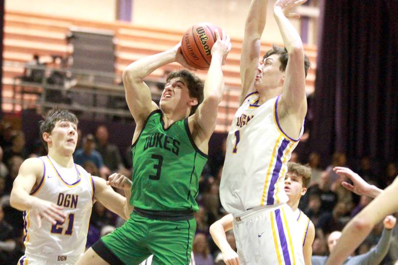 York’s A.J. Levine (center) attempts a shot between Downers Grove North’s Jack Stanton (left) and Jake Riemer (right) during a game at Downers Grove North on Friday, Jan. 19, 2024.