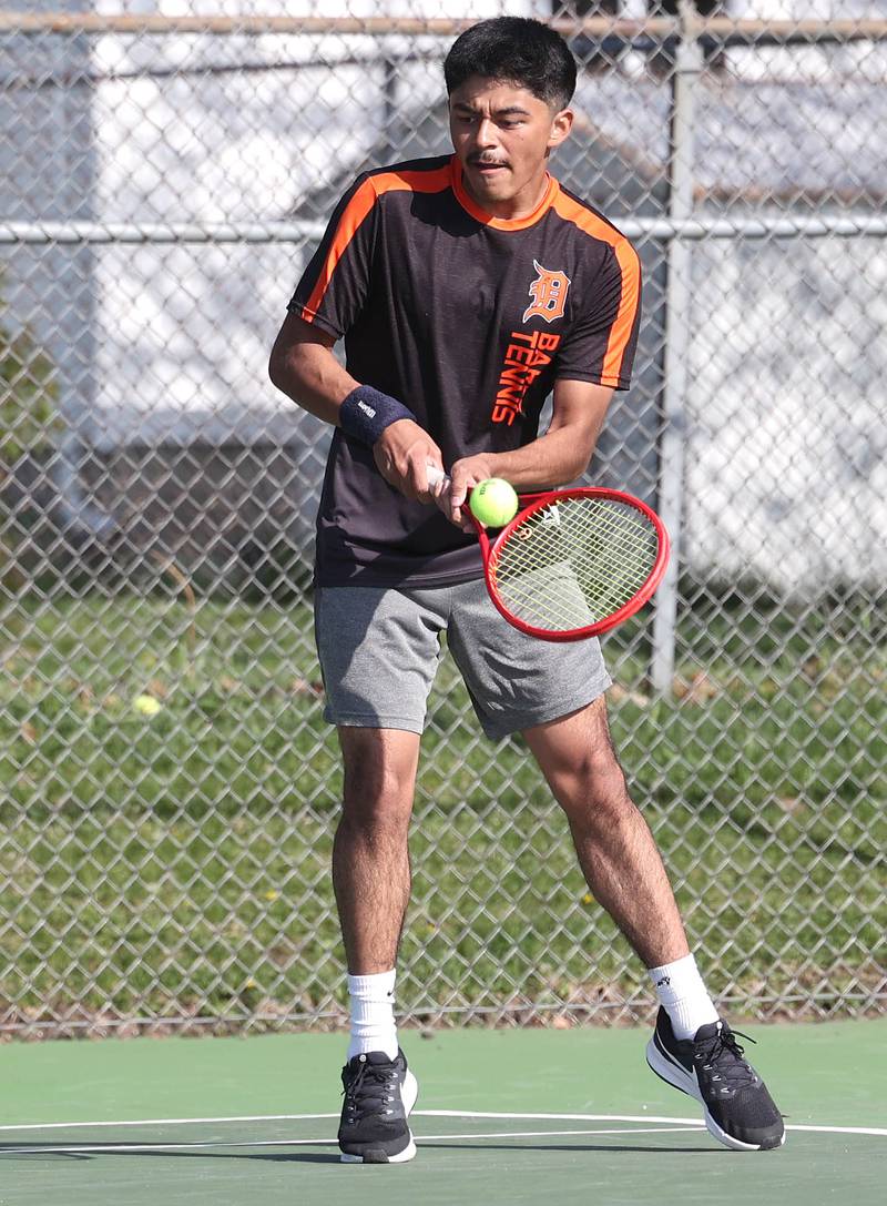 DeKalb number one doubles player Jared Trejo reaches to hits a backhand Wednesday, April 26, 2023, during their match at Sycamore High School.