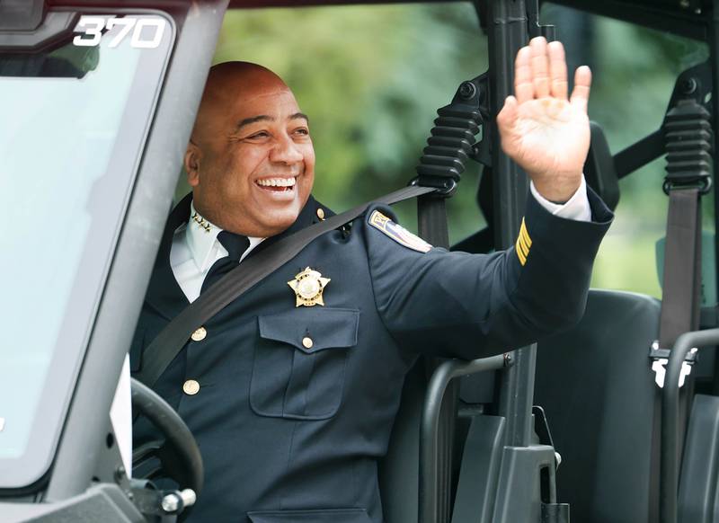 DeKalb Police Chief David Byrd waves to parade attendees as he makes his way down West Locust Street during the DeKalb Memorial Day parade Monday, May 27, 2024, on his way to Ellwood House for a Memorial Day ceremony.