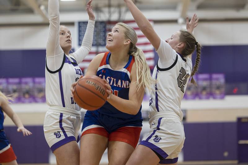 Eastland’s Olivia Klinefelter works below the basket against Dixon’s Makenzie Toms and Katie Drew Wednesday, Jan. 24, 2024 at Dixon High School.