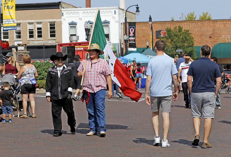 Josh Herrera and Derek Berstaio walk around the Historic Woodstock Square on Sunday, Sept. 15, 2024,, during the annual Hispanic Connections Mexican Independence Day Celebration in the Historic Woodstock Square. The celebration featured music, food and culture.