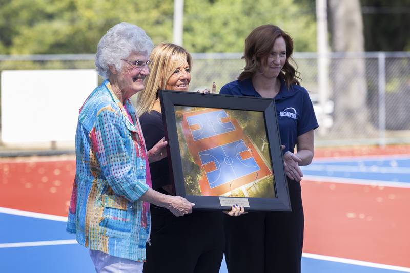 Louise Reed accepts a photo from Dixon Park District’s Michelle Lawson (middle) and Jana Halfacre Tuesday, Sept. 17, 2024, at the dedication of the Larry and Louise Reed Basketball Courts at Vaile Park.