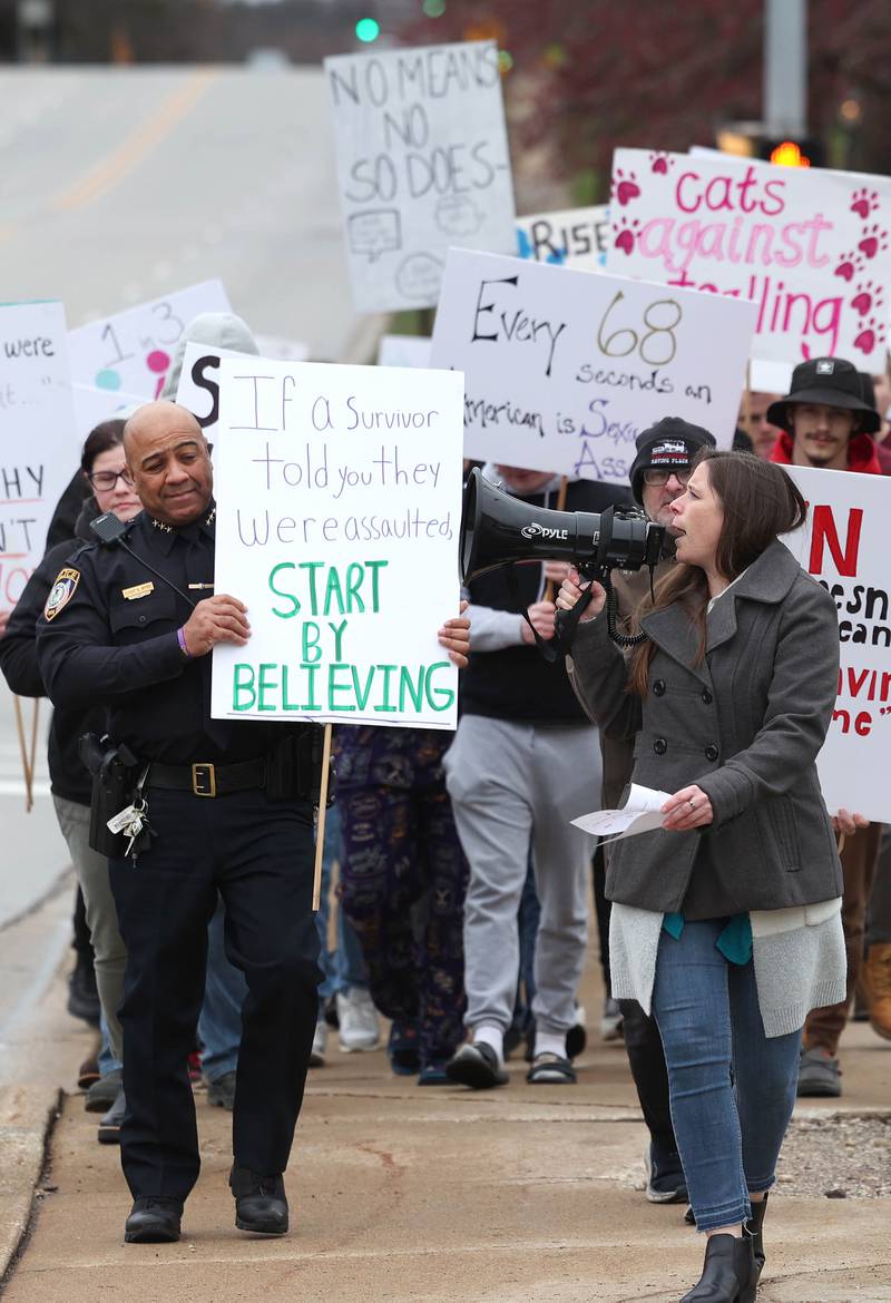 Kelsey Gettle, Safe Passage legal program manager, leads marchers in a chant Tuesday, April 2, 2024, on First Street, during Take Back the Night in DeKalb. The event, hosted by Safe Passage, is in honor of Sexual Assault Awareness Month and featured speakers and a march.