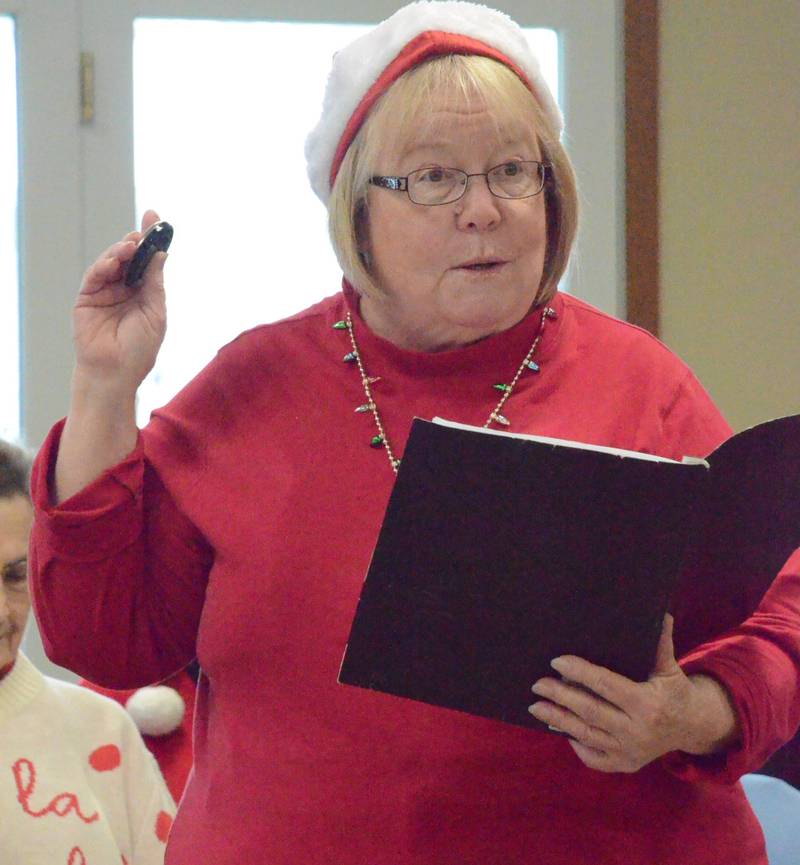 Joyce Schomer of Montgomery narrates and tells "groaner" jokes at a Dec. 16 concert by Oswego Senior Singers at Wedgewood Manor in Montgomery.